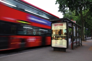 Adshel Live digital bus shelter screen displaying school open evening advertising UK